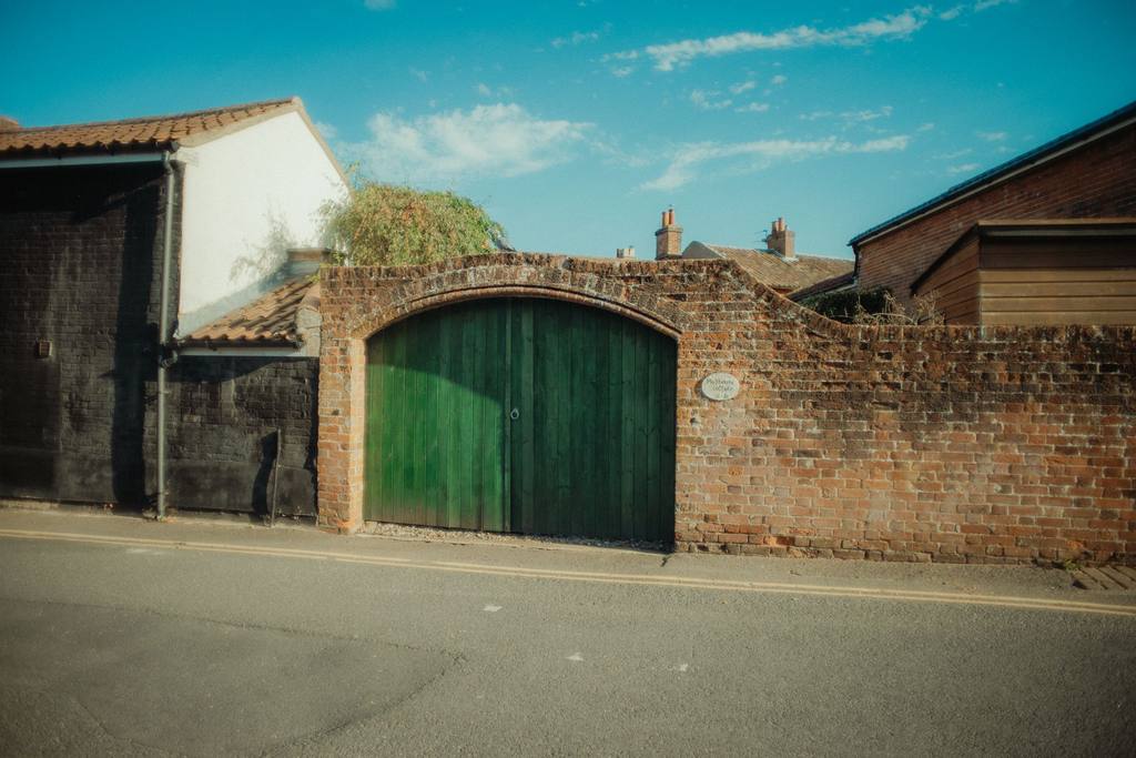 Brick garden wall with a green timber gate