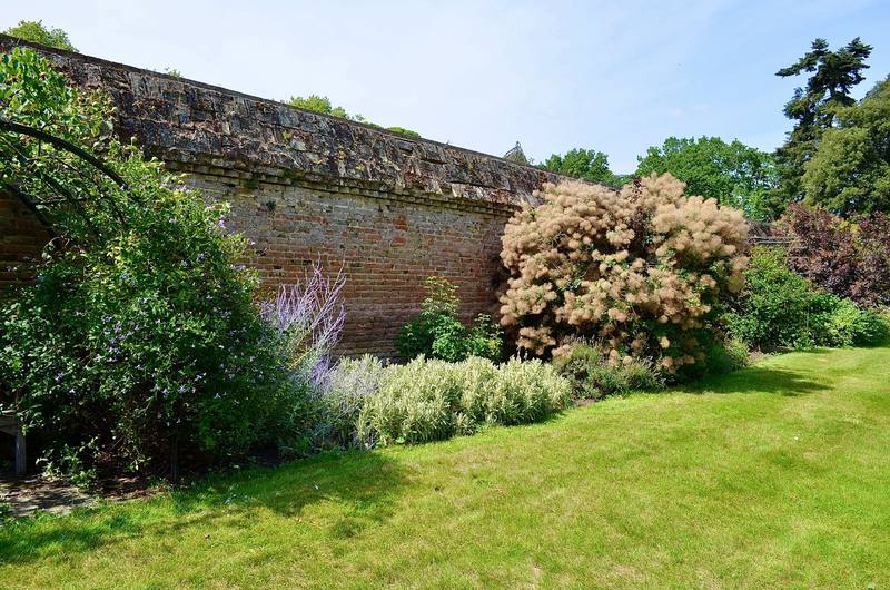 Garden lawn bordered by an old brick wall
